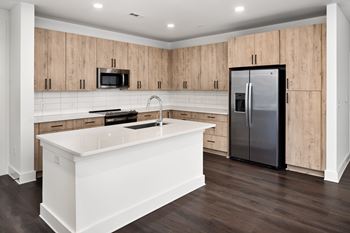 A modern kitchen with wooden cabinets and a white island.